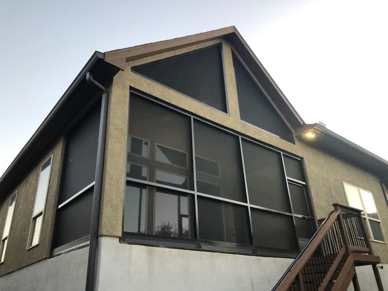 A screened in porch with stairs leading up to it