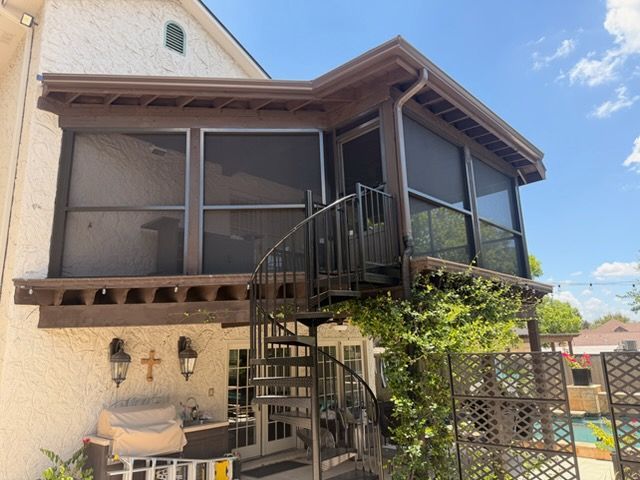 Screened patio with a white-framed door, wood deck, and railing on a suburban house exterior