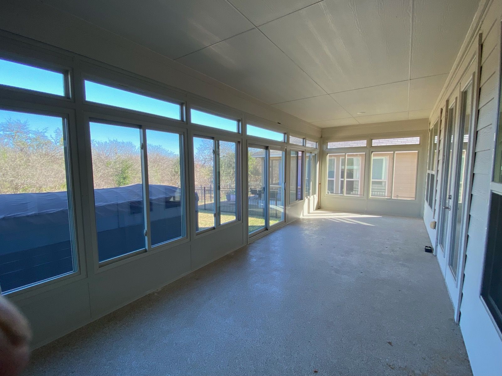 A house with a screened in porch and sliding glass doors.