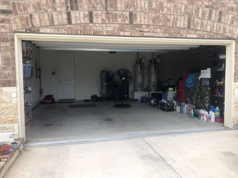 A garage with a fan in it and a brick wall