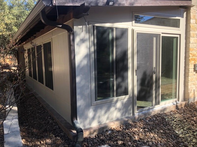 A house with a lot of windows and a sliding glass door.