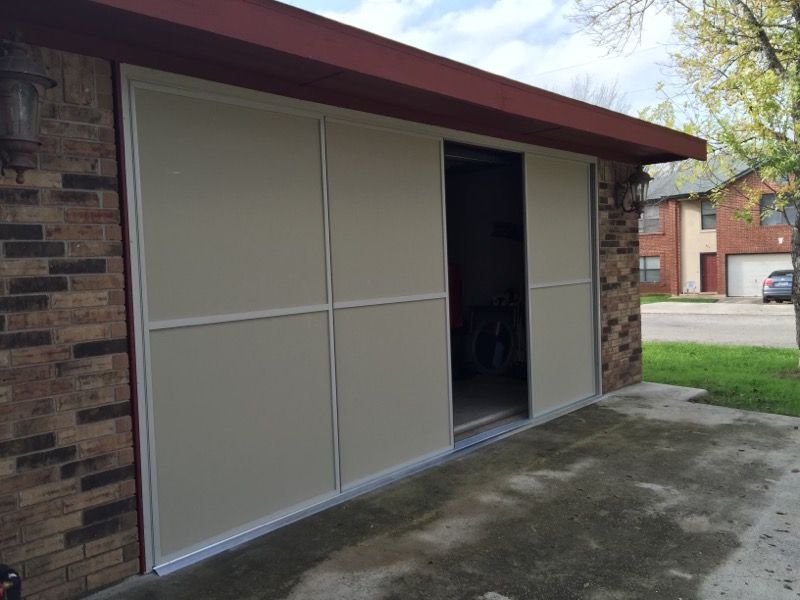 A garage with a sliding door and a brick wall