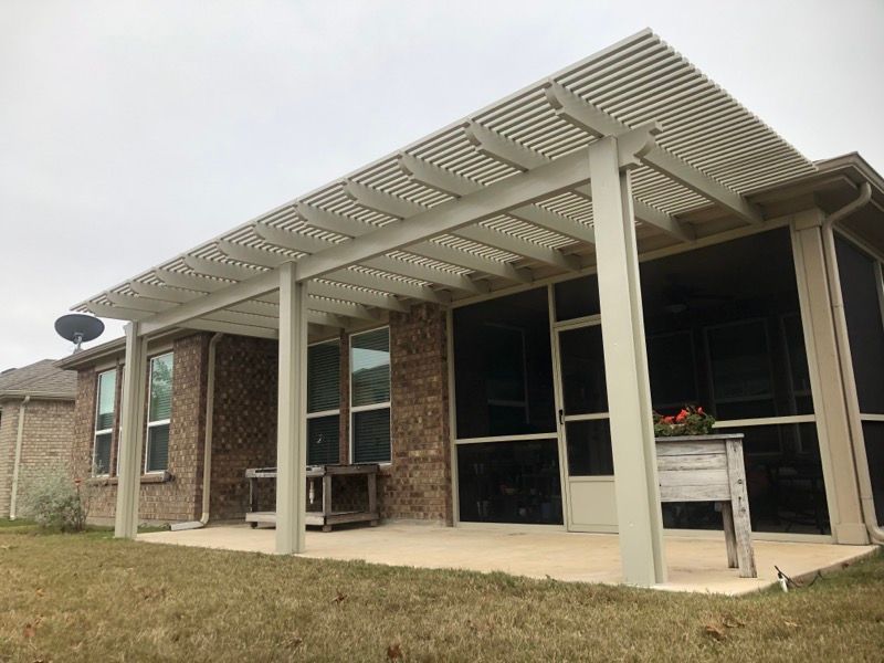 A house with a screened in porch and a pergola.