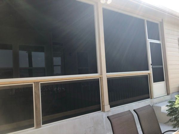A screened in porch with a couch and chairs