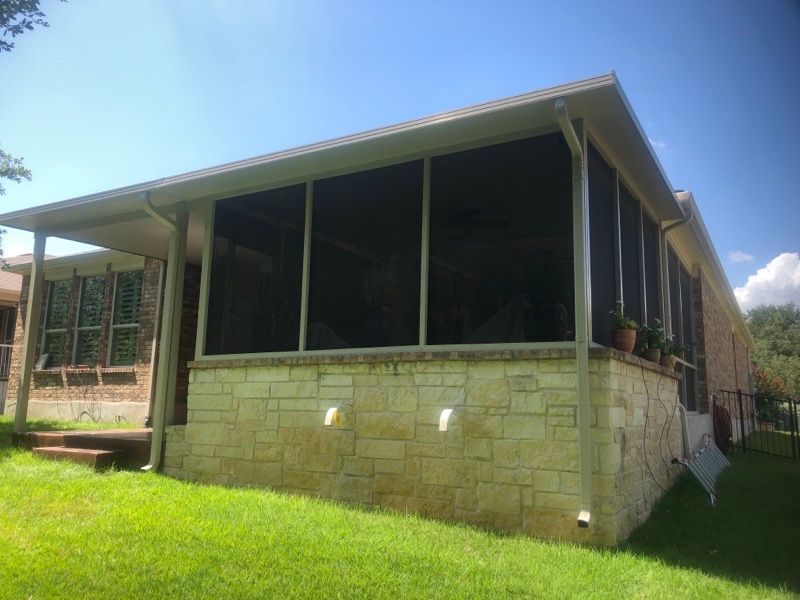 A house with a screened in porch on the side of it.
