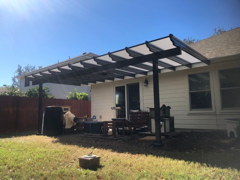 A white house with a pergola in the backyard