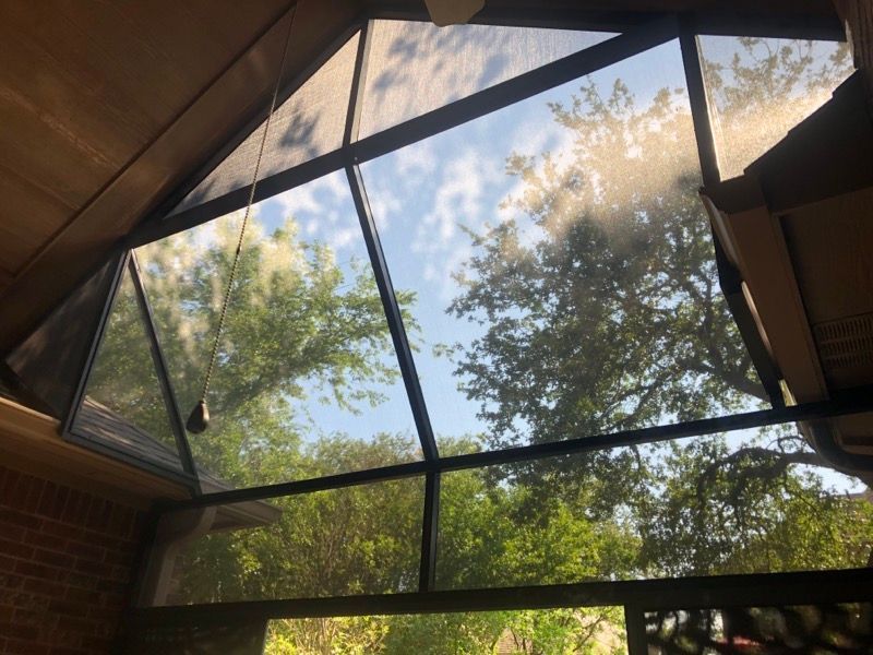 A screened in porch with trees in the background