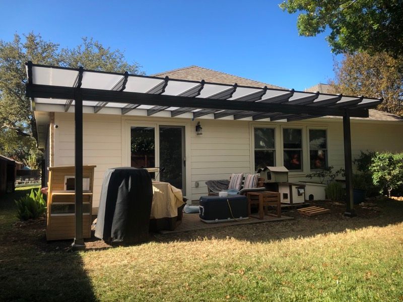 A white house with a pergola in the backyard