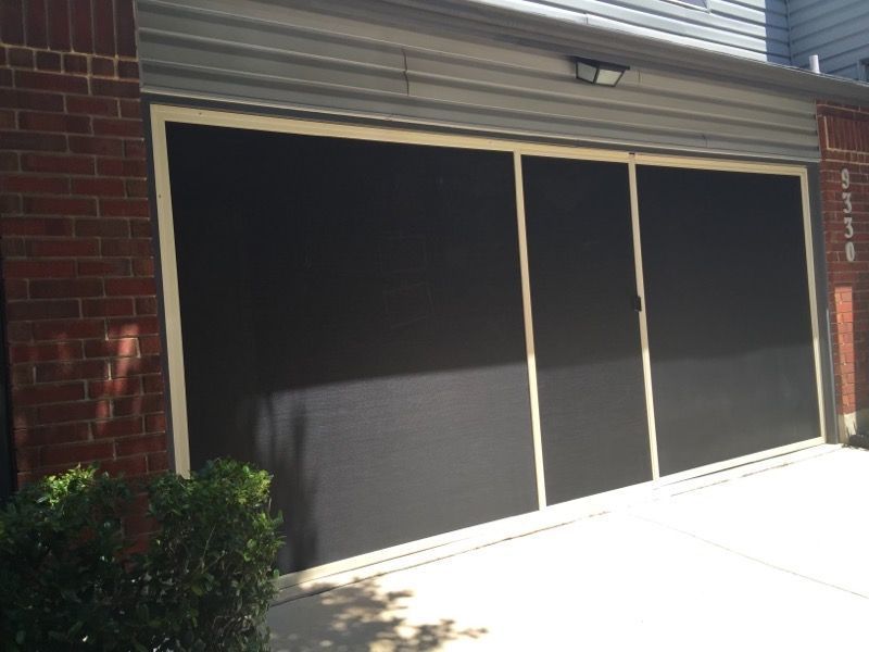 A brick building with a screened in garage door