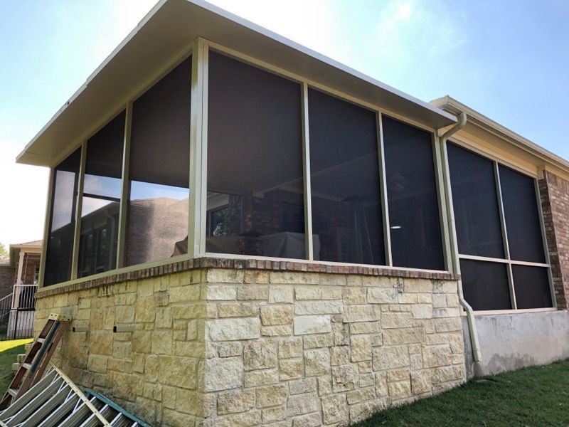 A screened in porch on the side of a house