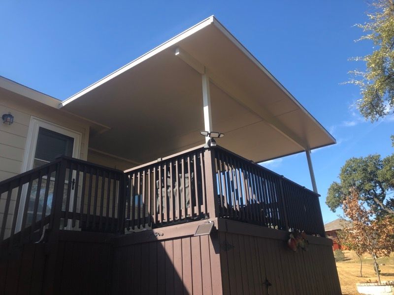 A house with a large deck with a white roof