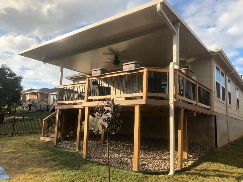A house with a covered deck and a ceiling fan.
