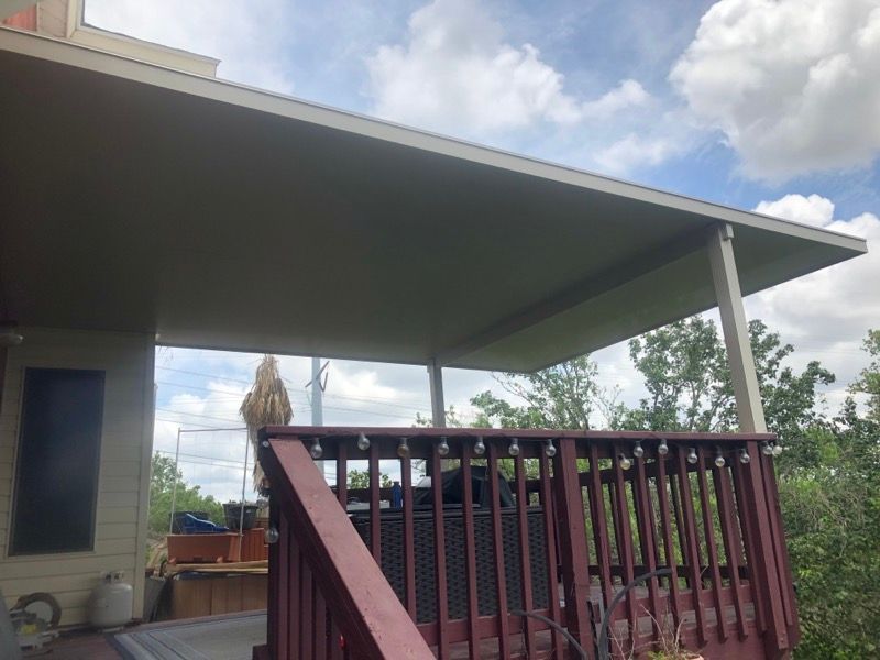 A deck with a covered patio and stairs leading up to it.