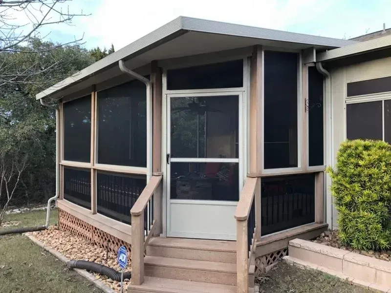 A screened in porch with stairs leading up to it