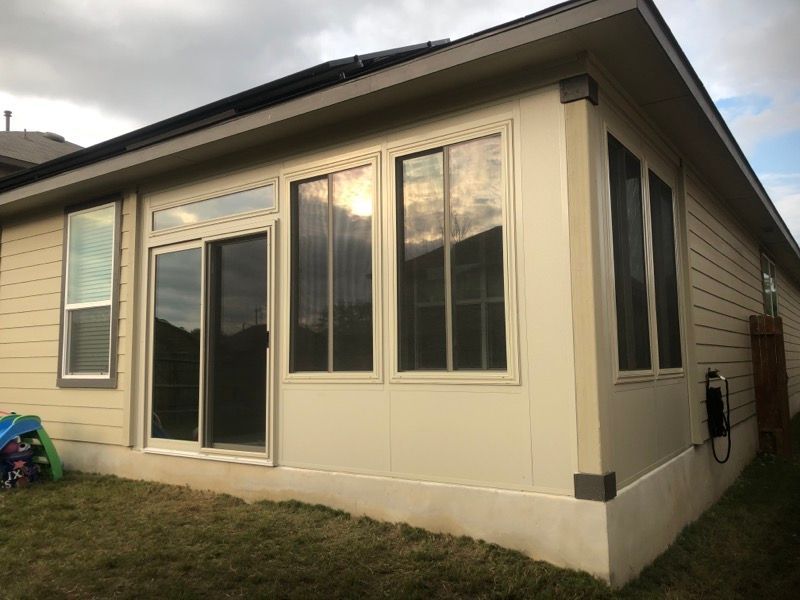 A house with a screened in porch and a lot of windows