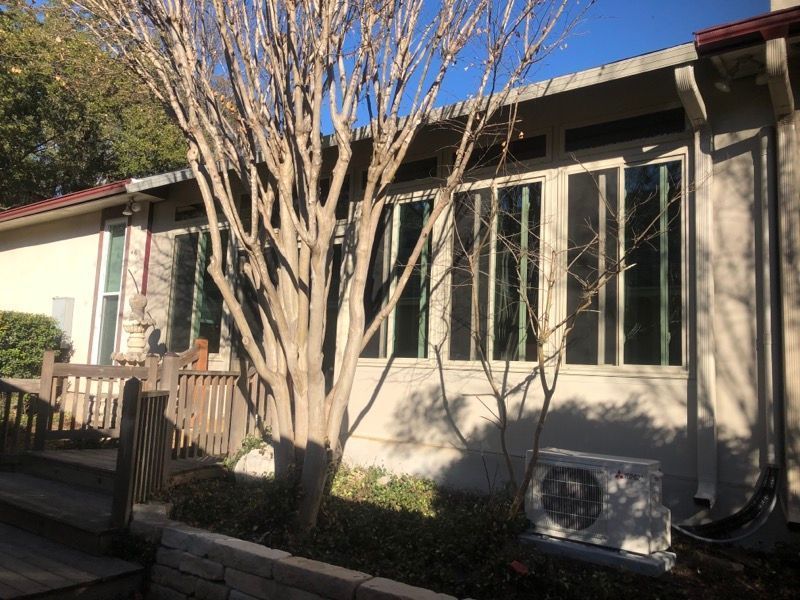 A house with a lot of windows and a tree in front of it