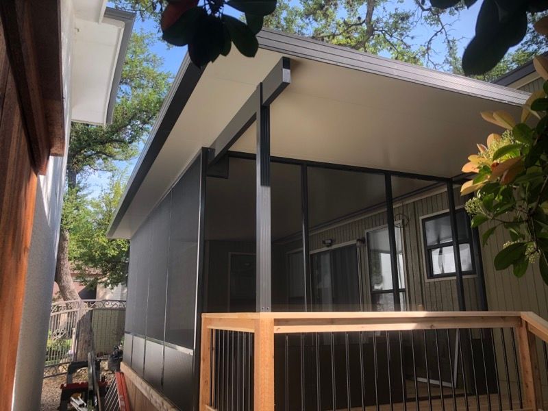 A house with a screened in porch and a wooden railing