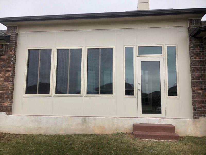 A white house with a lot of windows and a door.