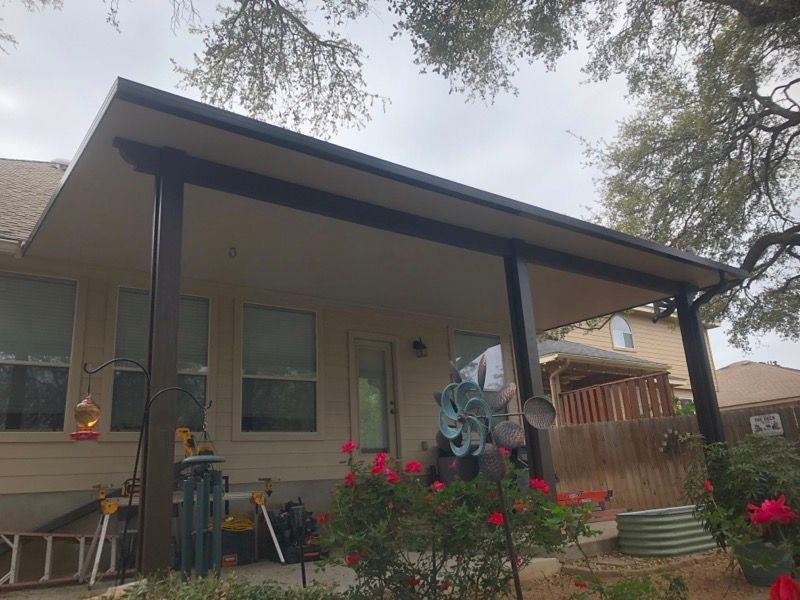 A house with a porch and flowers in front of it.