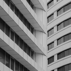 Black-and-white view of a modern apartment building facade with repeating balconies and windows