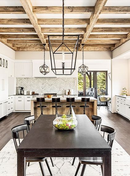 Modern farmhouse kitchen and dining room with dark wood table, white cabinets, and exposed beam ceiling