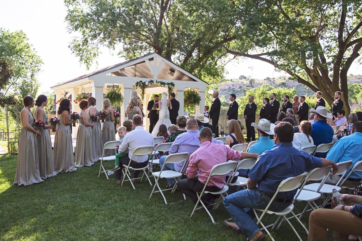 A group of people are sitting in folding chairs at a wedding ceremony.