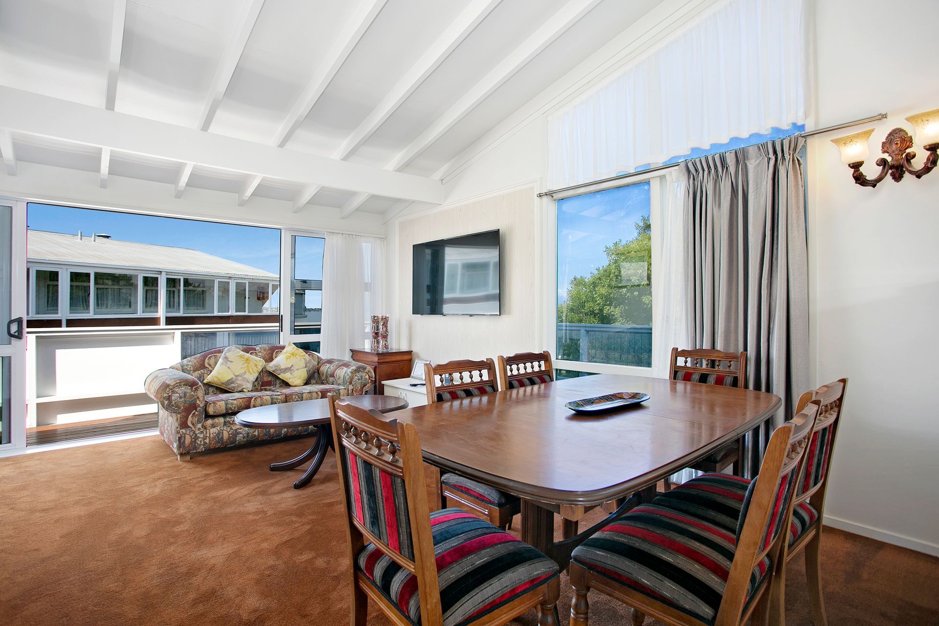 A living room with a dining table and chairs and a couch.
