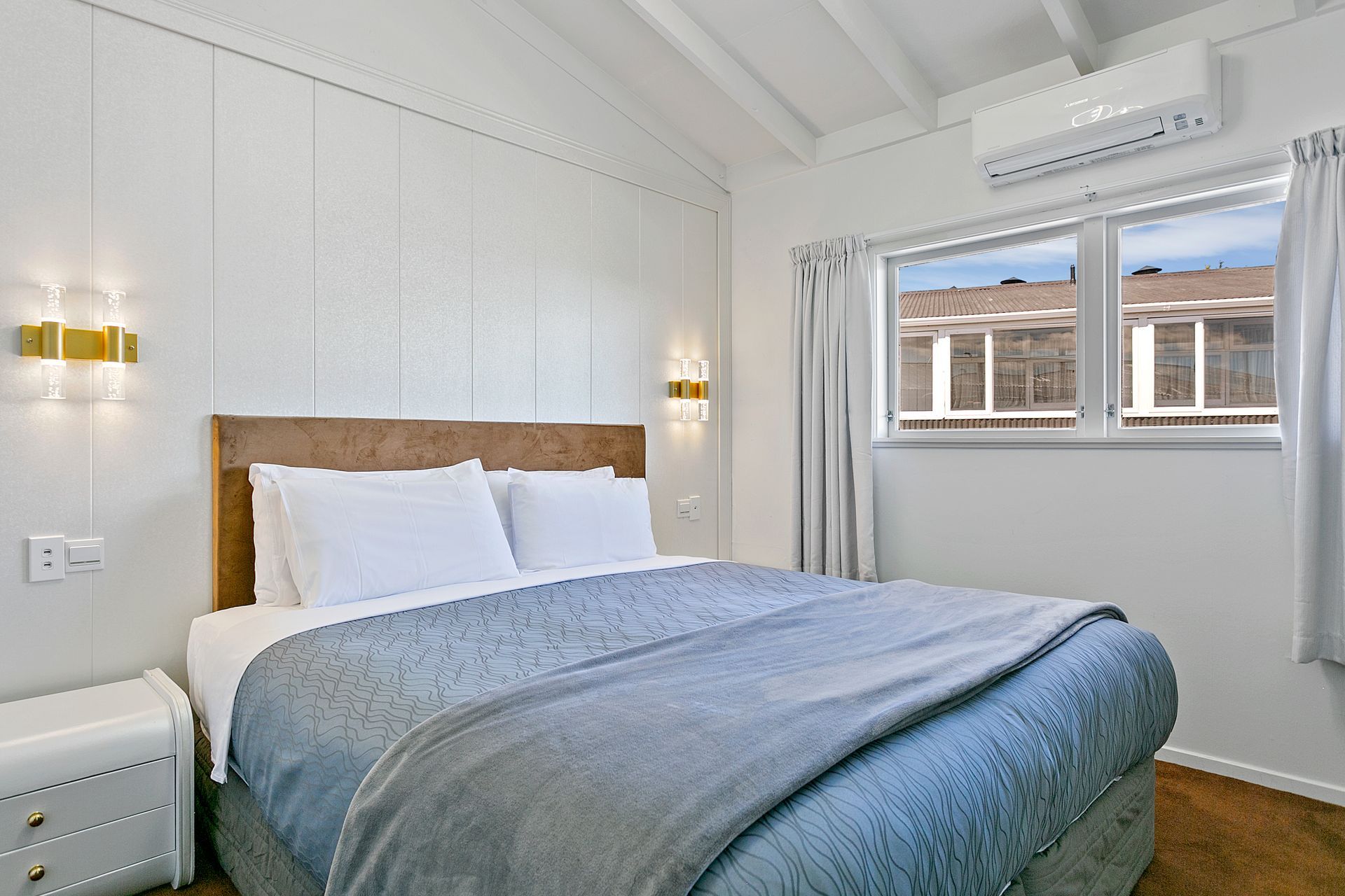 A bedroom with a king size bed and a window.