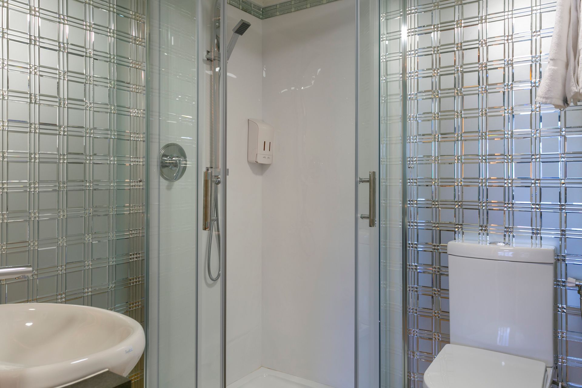 A bathroom with a toilet , sink and shower stall.