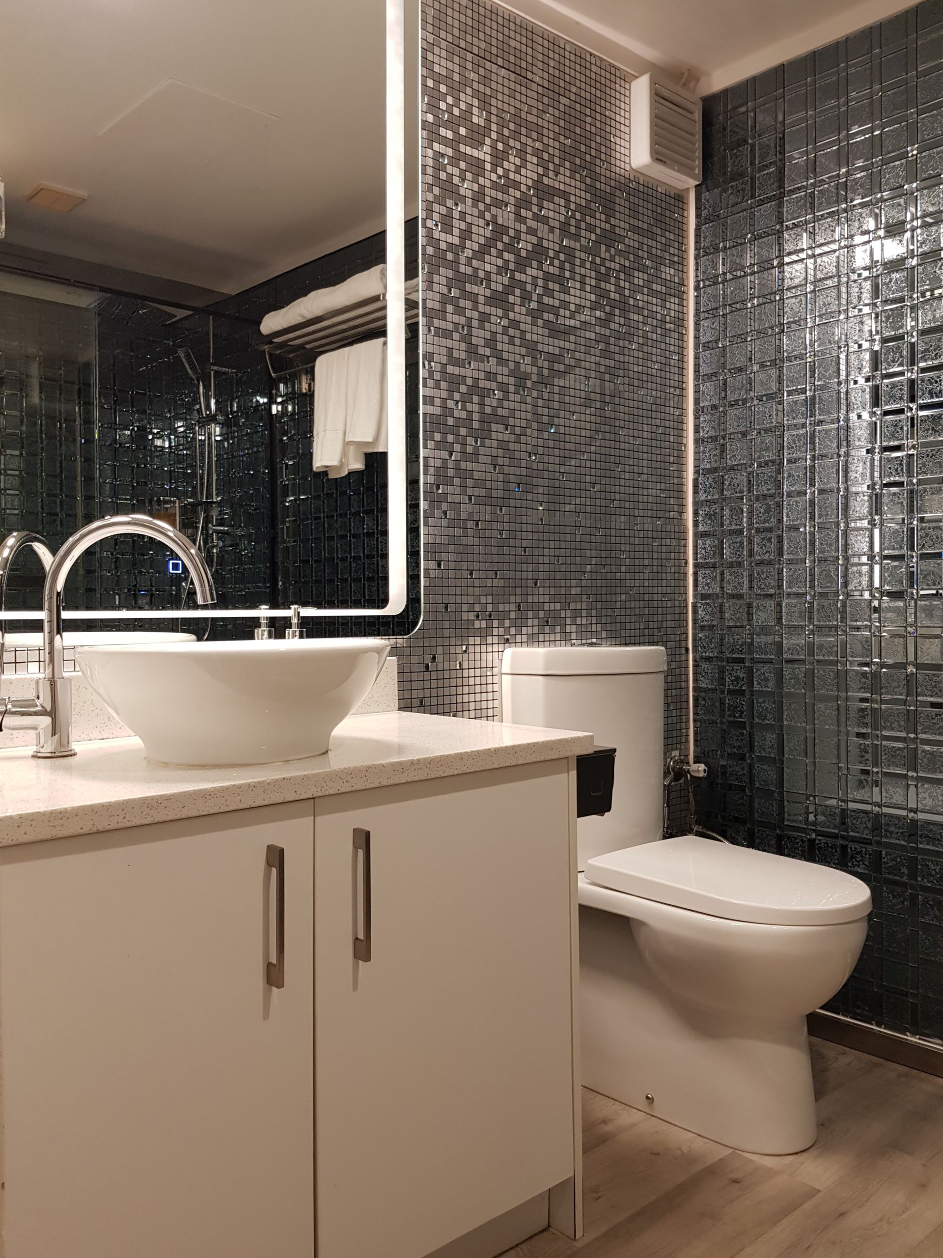 A bathroom with a sink , toilet and mirror.