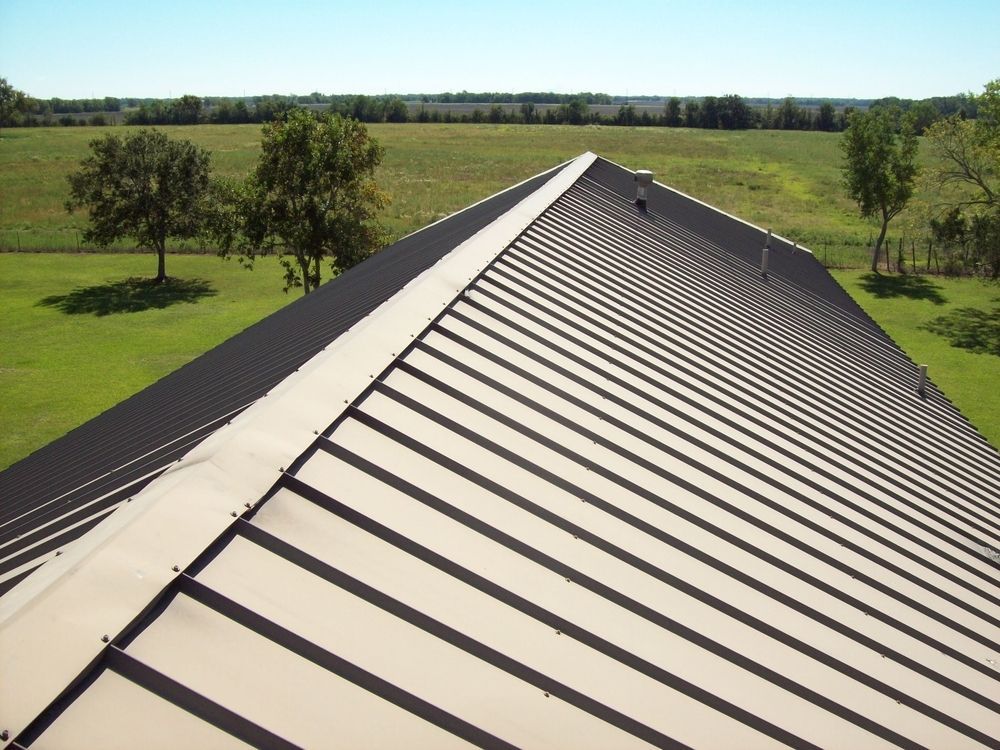 The Roof of a Building With Trees in the Background — Bradshaw Plumbing & Roofing Pty Ltd In Ooralea, QLD