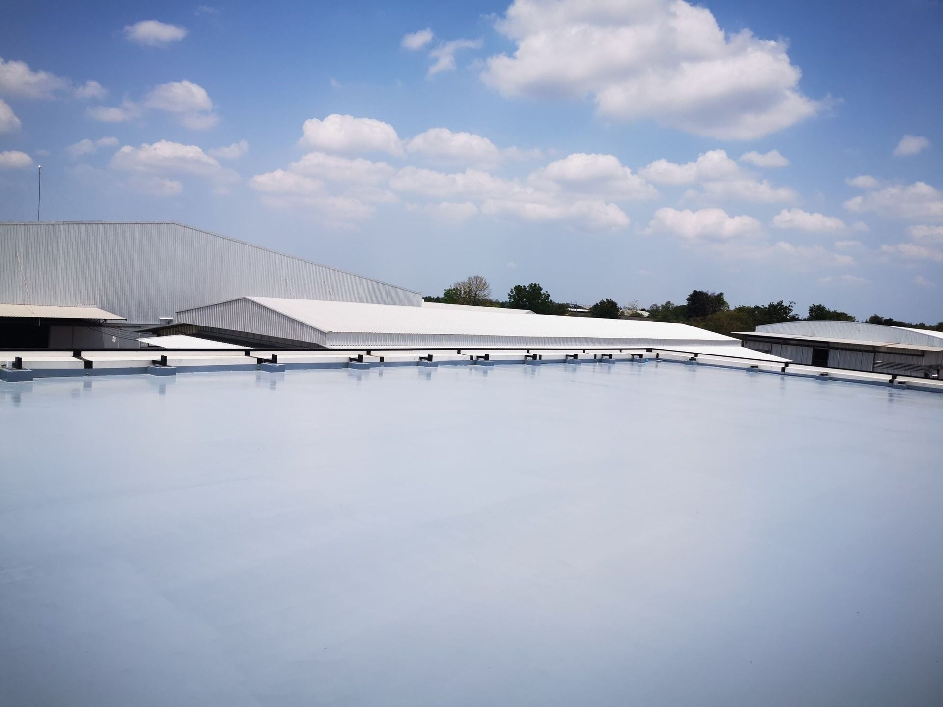 A Large White Building With a Blue Sky in the Background — Bradshaw Plumbing & Roofing Pty Ltd In Marian, QLD