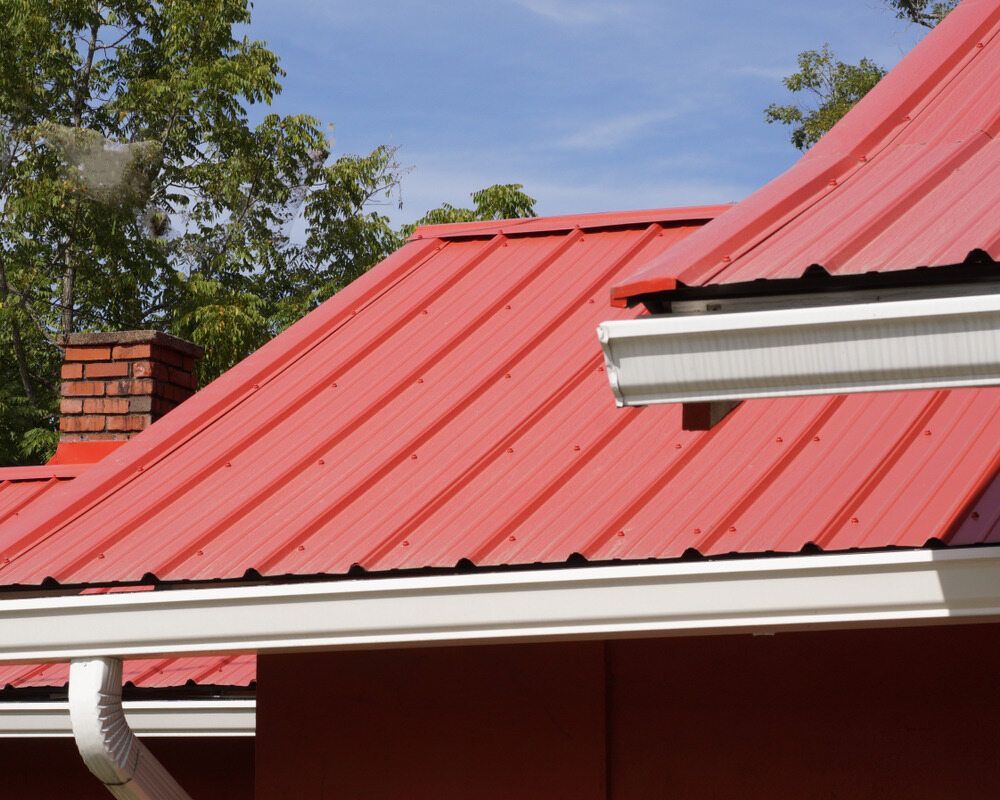 A Red Roof With a White Gutter and a Chimney — Bradshaw Plumbing & Roofing Pty Ltd In Ooralea, QLD A Red Roof With a White Gutter and a Chimney — Bradshaw Plumbing & Roofing Pty Ltd In Ooralea, QLD