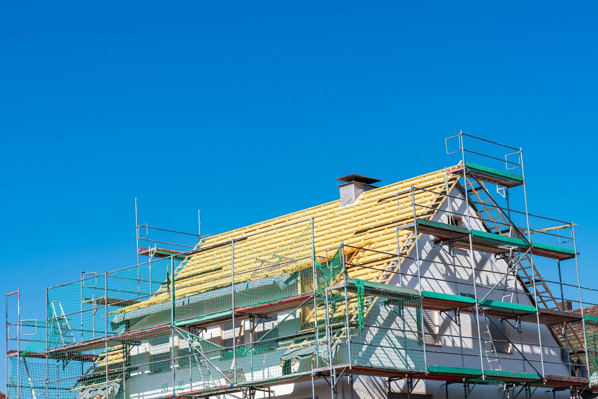 A House is Being Built With Scaffolding and a Wooden Roof — Bradshaw Plumbing & Roofing Pty Ltd In Marian, QLD