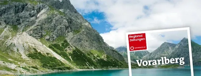 Ein Bild von einem See mit Bergen im Hintergrund und einem Schild mit der Aufschrift Vorarlberg