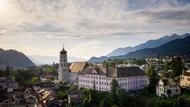 Eine Luftaufnahme einer Stadt mit Bergen im Hintergrund.