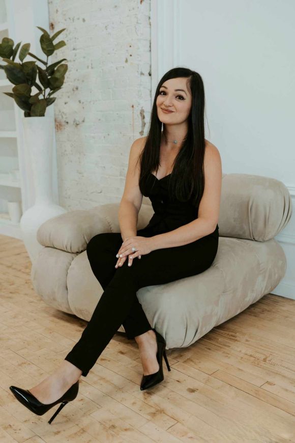 A woman is sitting on a chair with her legs crossed.