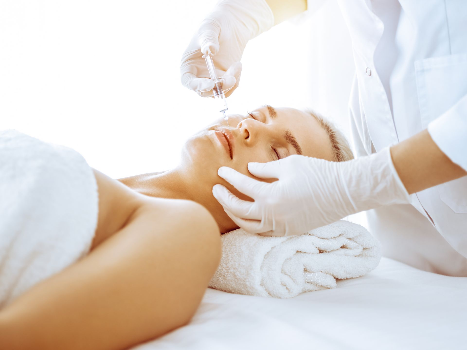 A woman is getting an injection in her face at a spa.