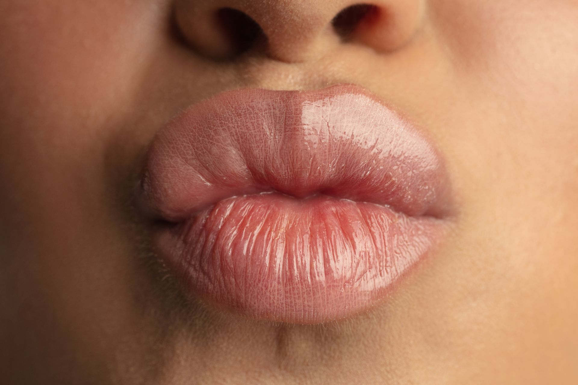 A close up of a woman 's lips blowing a kiss.