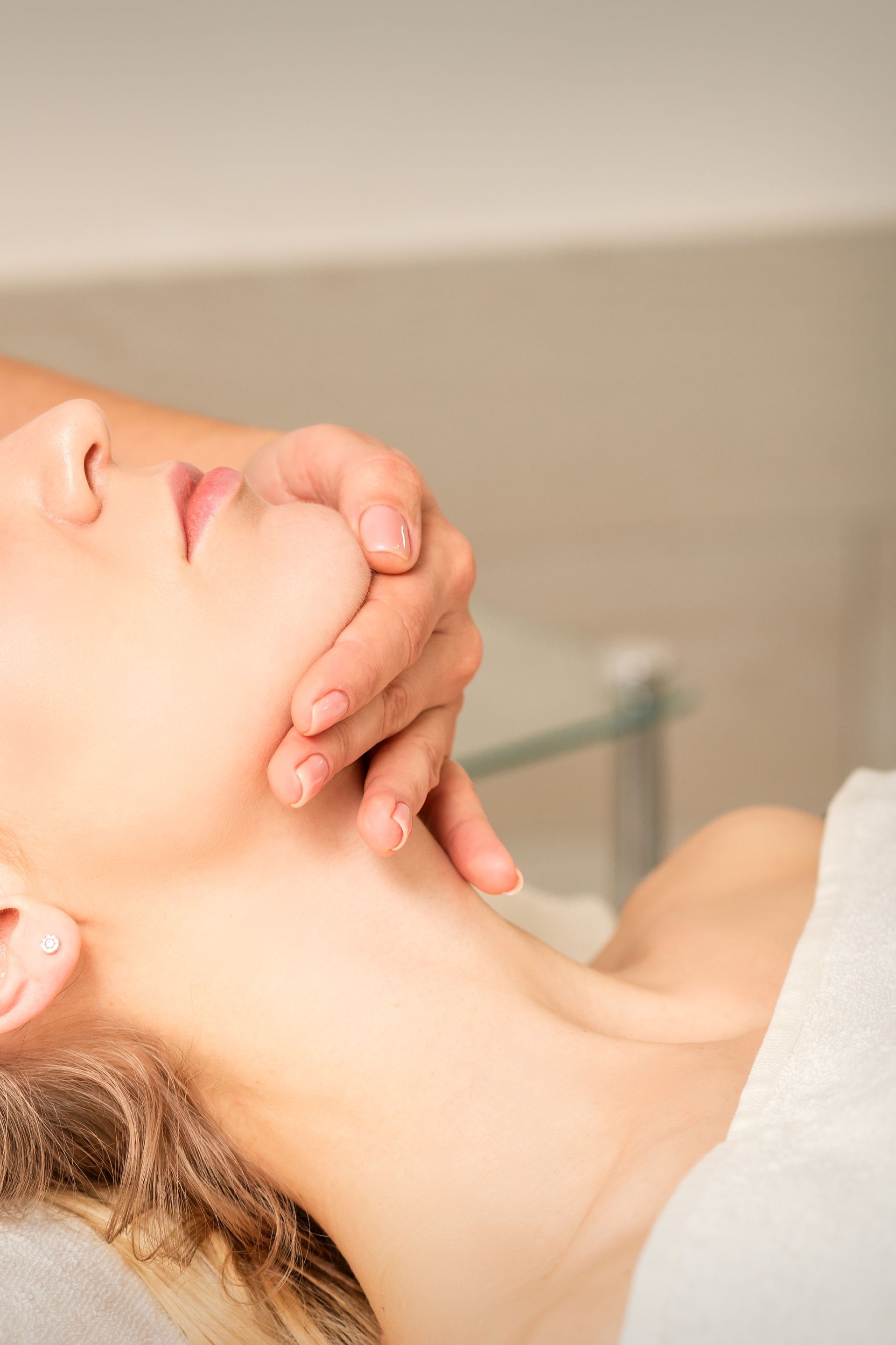 A woman is getting a massage on her face at a spa.
