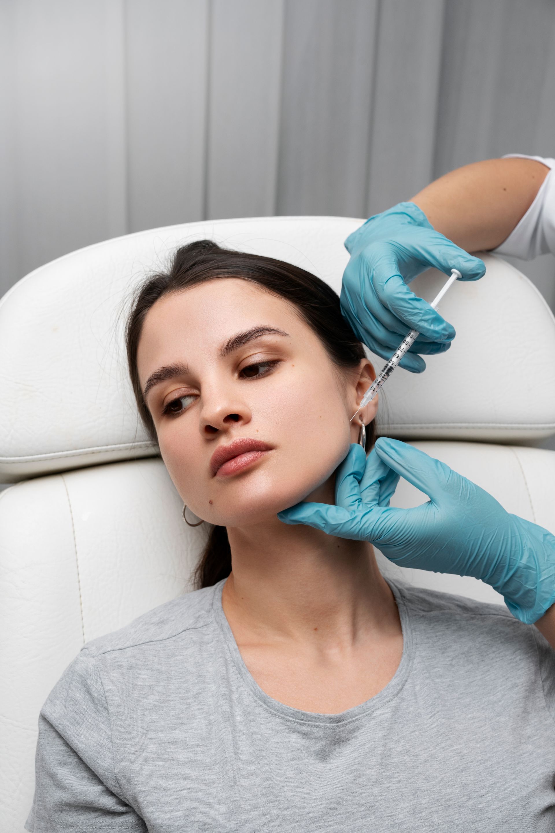 a woman is getting a botox injection in her face .