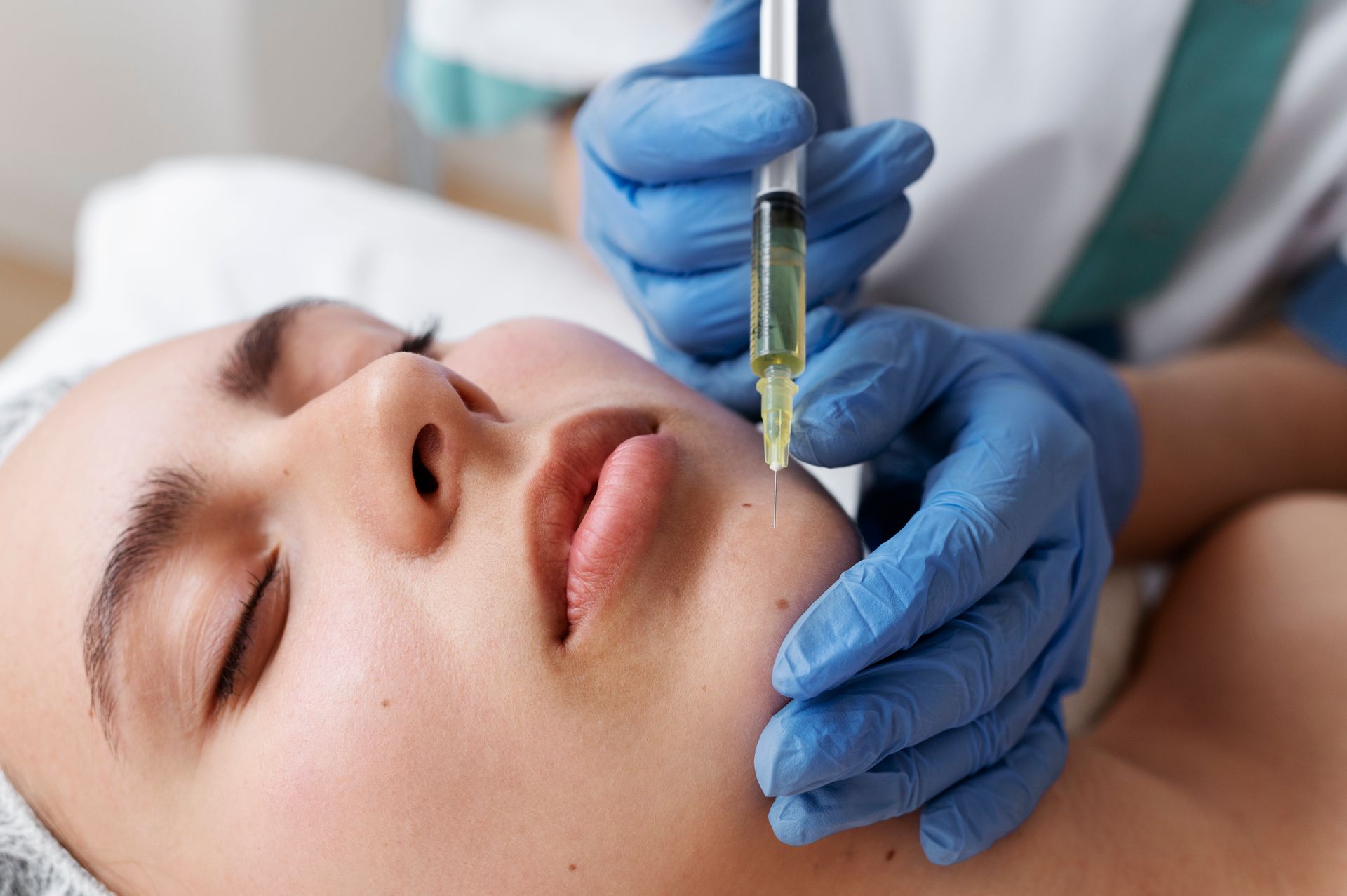 A woman is getting a botox injection in her face.