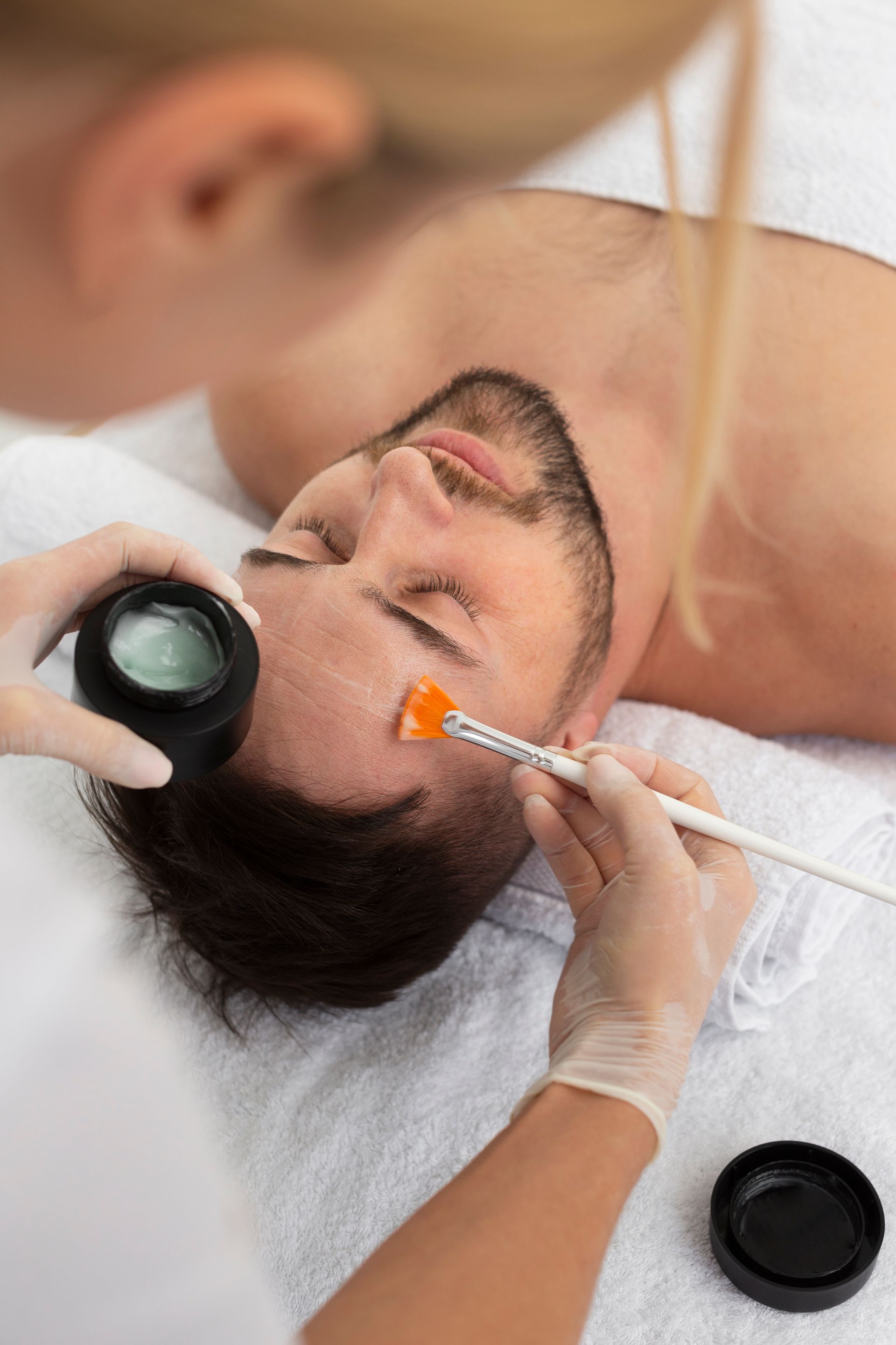 A man is getting a facial treatment at a spa.