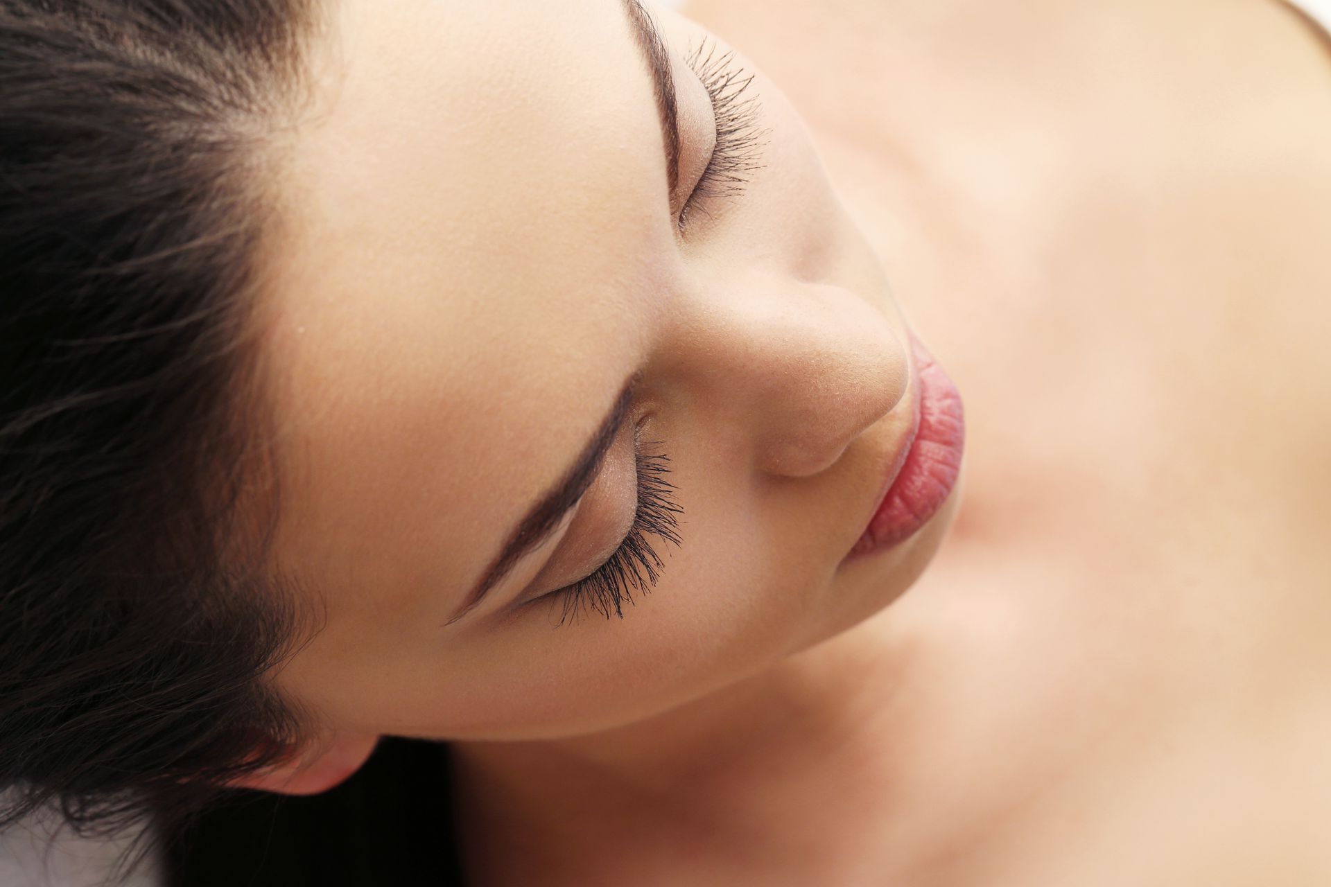 a close up of a woman 's face with her eyes closed .