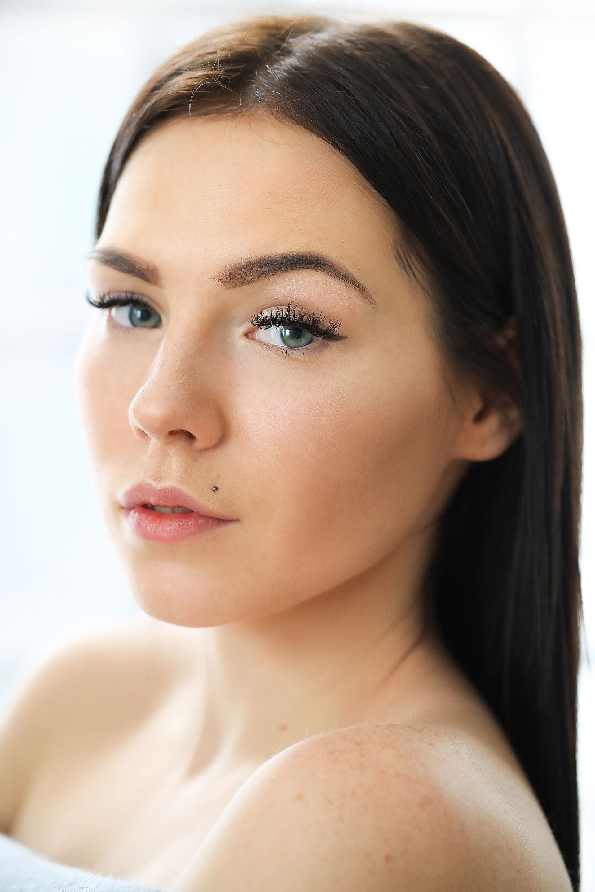 a close up of a woman 's face with long hair and blue eyes .