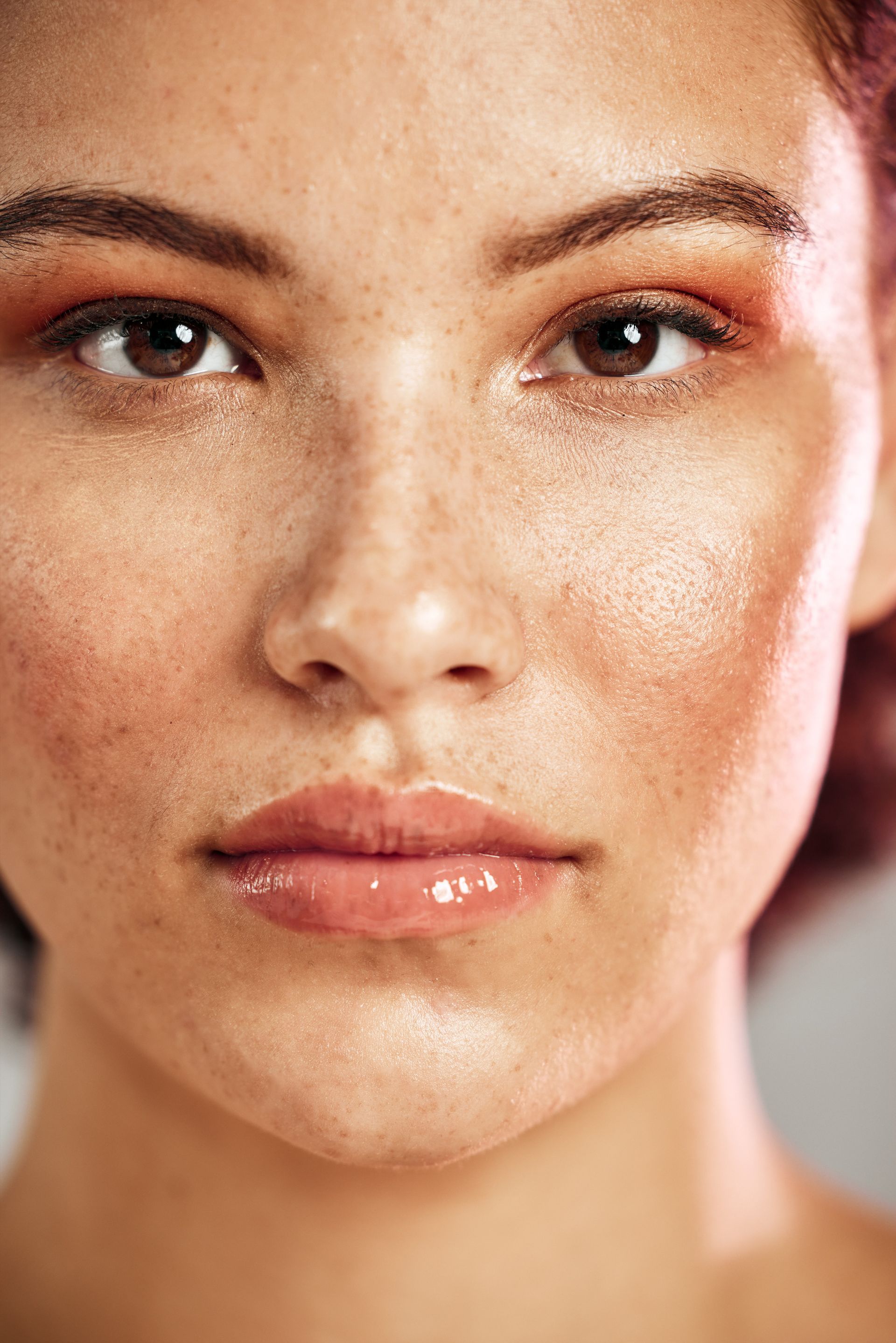 A close up of a woman 's face with freckles and makeup.