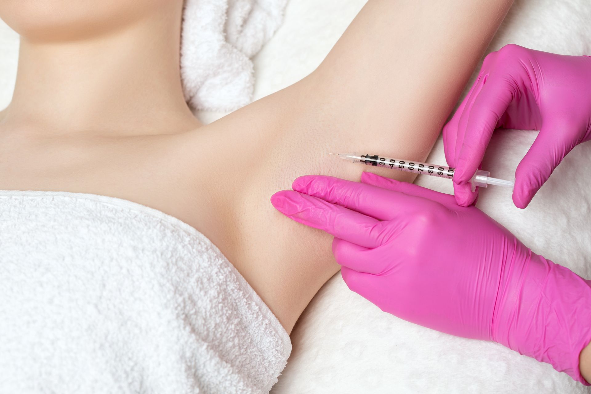 A woman is getting an underarm injection in a beauty salon.