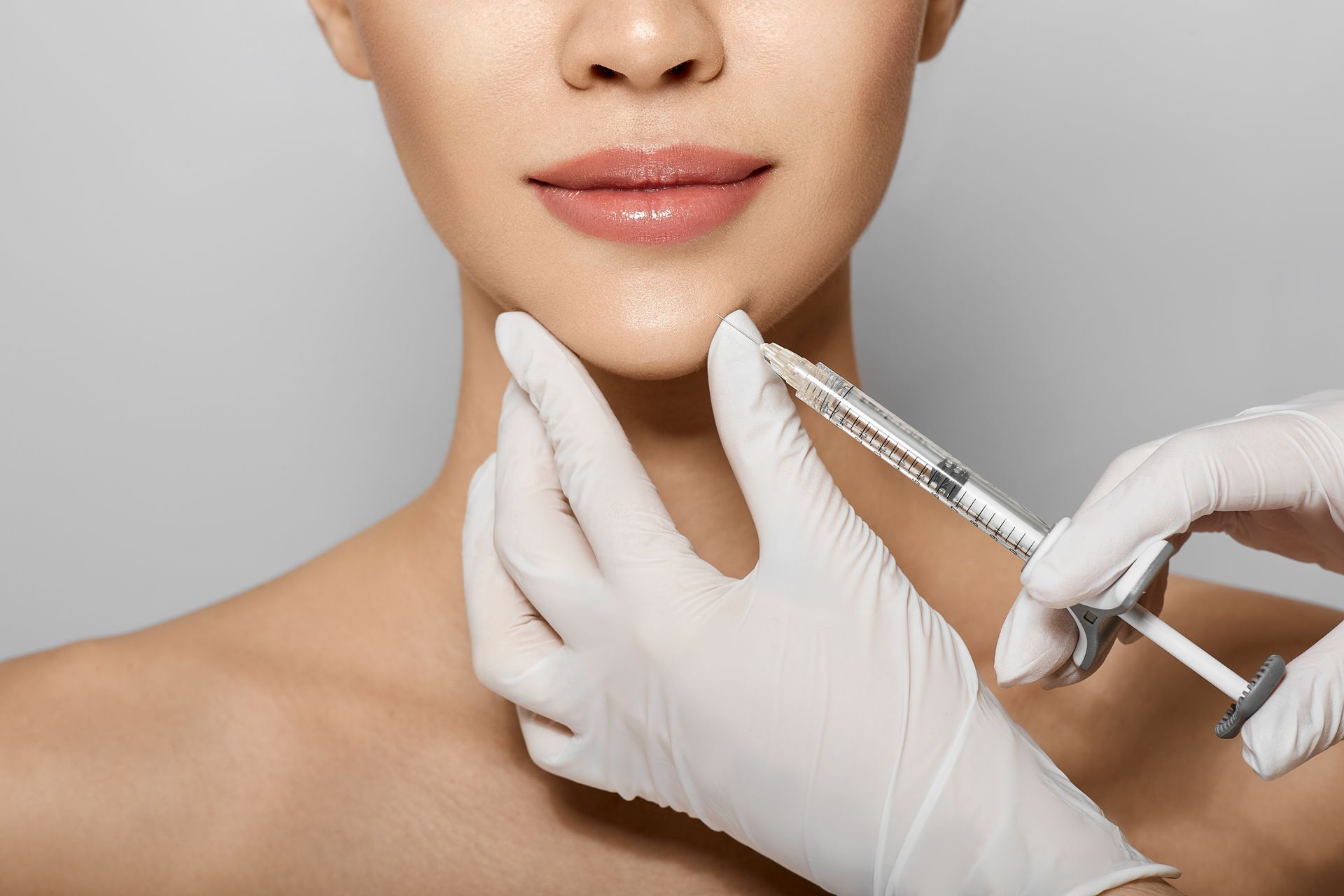 A woman is getting a botox injection in her face.