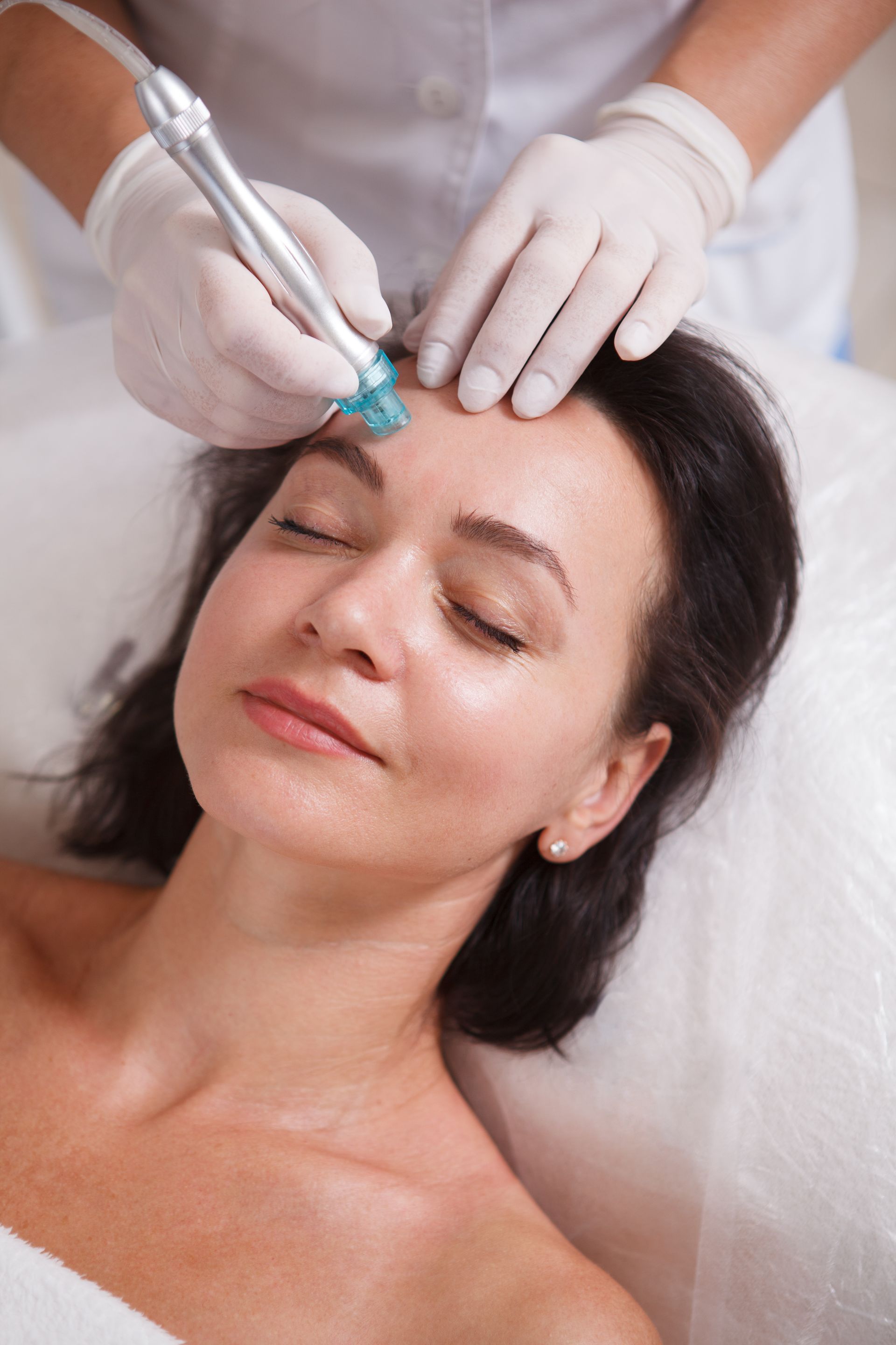 A woman is getting a facial treatment at a beauty salon.