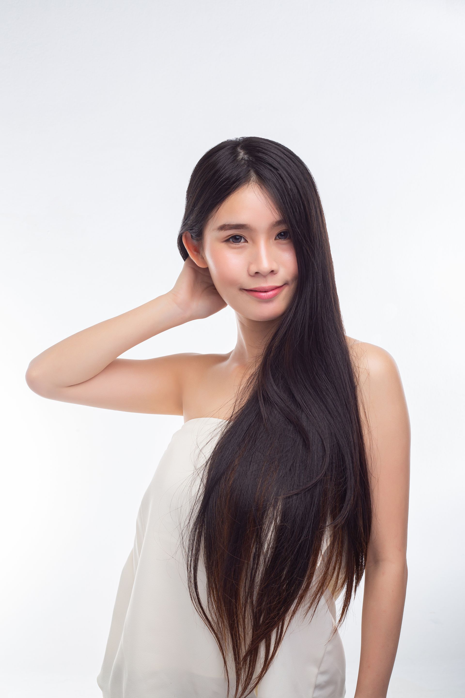A woman with long hair is wrapped in a white towel.